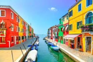 a group of colorful buildings next to a canal with boats at Stella di Mare - Cà Savio in Cavallino-Treporti