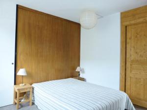 Résidence Mustag - Appartement 3 pièces - Plagne Centre MAE-4754 في آيم لا بْلانيِ: غرفة نوم بها سرير وجدار خشبي