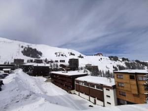 Résidence Mustag - Appartement 3 pièces - Plagne Centre MAE-4754 في آيم لا بْلانيِ: مدينه مغطاه بالثلج بالمباني والجبل +صورتان