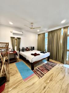 a bedroom with a bed and a large window at Secret Garden Agonda Beach Resort in Agonda