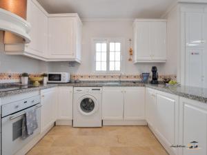 a white kitchen with white cabinets and a dishwasher at CASA DE FLAMENCO in Orihuela Costa