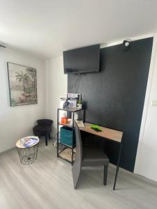 a room with a desk and a table with a chair at Chambre safari individuelle avec partie commune A 6min de l A26 et 15 min de stOmer, lumbres et aire sur la lys in Ecques