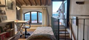 a room with a desk and a table and a window at La Casa del Gallo in Radicondoli