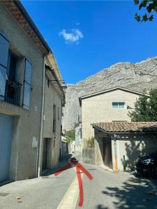 a red ribbon on a street next to two buildings at Tour de Babel in Sisteron +8 photos