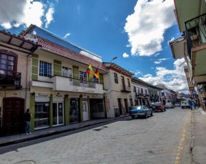 ulica w mieście z samochodami zaparkowanymi na ulicy w obiekcie Hotel Las Gardenias w mieście Cuenca