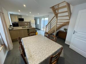 a kitchen and dining room with a table and a staircase at Wissant Maison Chez Jeanne in Wissant