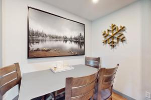 een eettafel met stoelen en een foto aan de muur bij Beaver Creek Bungalow in Avon