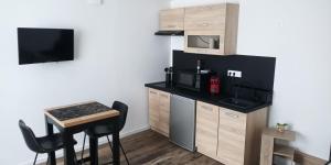 a small kitchen with a small table and a microwave at La Pierre 2 studio entier in Tartas