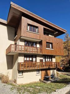 a house with a wooden balcony on the side of it at Résidence Gaubert - Mignon petit studio 4 couchages à Vars MAE-9981 in Vars