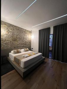 a bedroom with a large bed and a stone wall at Luxury Marina apartments in Rijeka