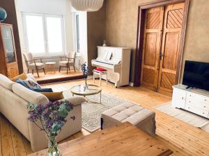 a living room with a couch and a piano at Robins Nest - Charmanter Altbau, 80 m2, zentral & ruhig in Detmold