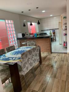 Barra do Rio AbaixoにあるCasa com piscinaのテーブルと椅子のあるキッチンとダイニングルーム