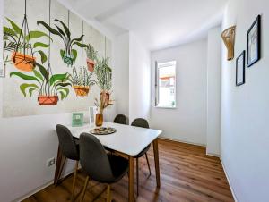 a dining room with a white table and chairs at BohnApartments - Design Suiten Am Markt - Vollausstattung - WLAN - Zentrum in Ilmenau