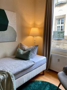 a bed in a room with a lamp and a window at Ba Em City Apartment in Wiesbaden