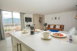a kitchen with a counter with cups and plates of food at Charming Decor & Stunning Views Green Poblado in Medellín