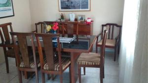 ein Esszimmer mit einem Holztisch und Stühlen in der Unterkunft Linda Casa Térrea em Xangri-Lá in Xangri-lá + 10 Fotos