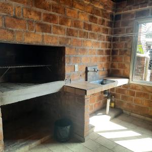 a kitchen with a sink and a brick wall at Casa 2 dormitorios B in Villa Guntz +3 photos
