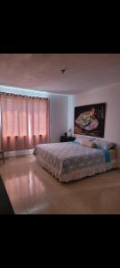 une chambre avec un grand lit et une fenêtre dans l'établissement Rincon Familiar, à Arecibo