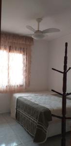 Schlafzimmer mit einem Bett, einem Ventilator und einem Fenster in der Unterkunft Linda Casa Térrea em Xangri-Lá in Xangri-lá