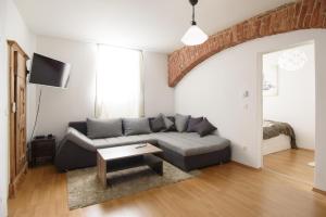 ein Wohnzimmer mit einem Sofa und einem Tisch in der Unterkunft Vienna Living Apartments - Währing in Wien
