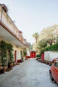 an empty street with a red car parked in front of a building at Il Gufo e l' Allodola in Caiazzo