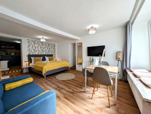 a bedroom with a bed and a desk and a couch at BohnApartments - Design Suiten Am Markt - Vollausstattung - WLAN - Zentrum in Ilmenau