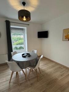a dining room with a table and chairs and a window at Studio 2ème étage - Centre-ville - Local vélos disponible in Mayenne