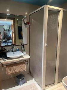 a bathroom with a sink and a shower with a mirror at Eden in Dar Bouazza