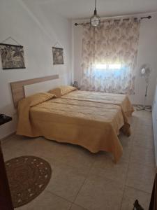 a bedroom with a large bed and a window at APARTAMENTO EL RINCÓN in La Restinga