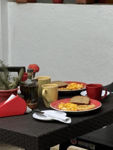 a table with two plates of eggs and toast at Casa Orquidea Hostal Barichara in Barichara