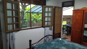 1 dormitorio con ventanas y 1 cama en una habitación en casa DOM, en Le Robert