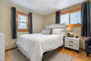 a bedroom with a white bed and a window at Triceratops Landing I Fire Place I Games I Netflix in Drumheller