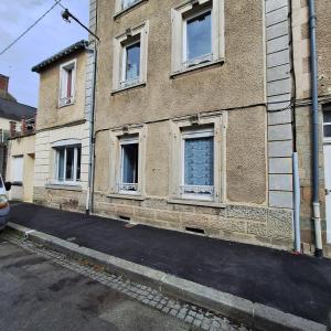 a building with boarded up windows on a street at Studio 2ème étage - Centre-ville - Local vélos disponible in Mayenne