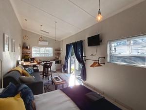 a living room with a bed and a dining room at Dalau on Main in Paarl
