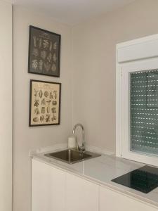 une cuisine blanche avec un évier et une fenêtre dans l'établissement Molinero, à Vejer de la Frontera