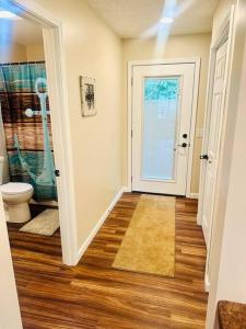 a hallway with a bathroom with a toilet and a door at School Section Cottage Lake Access in Mecosta