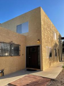 a brown building with a door and a staircase at Cheerful & Relaxing 5 Location Pool Parking in Tucson +22 photos