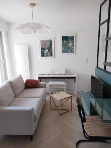 a living room with a couch and a piano at La parenthèse in Cabourg