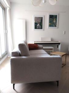 a living room with a couch and a piano at La parenthèse in Cabourg