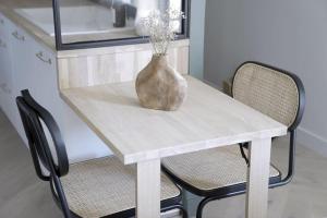 a white table with two chairs and a vase on it at La parenthèse in Cabourg +19 photos