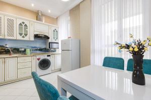 een keuken met een tafel, stoelen en een koelkast bij Apartment with Terrace-Апартаменты с террасой, ЭКСПО, Mega Silky Way in Astana
