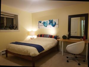 a bedroom with a bed and a desk and a mirror at Angela's Private Suites in Surrey