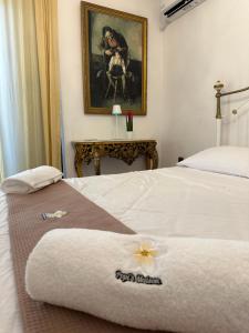 a bedroom with a white bed with a picture on the wall at Popis Maison in Rhodes Town +52 photos