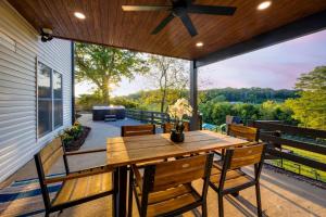 an outdoor patio with a wooden table and chairs at 27 South - Large Lux Retreat With Hot Tub & Gameroom in Thompsons Station