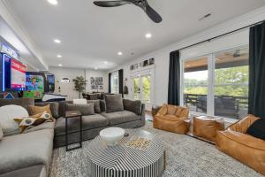 a living room with a couch and chairs and a tv at 27 South - Large Lux Retreat With Hot Tub & Gameroom in Thompsons Station