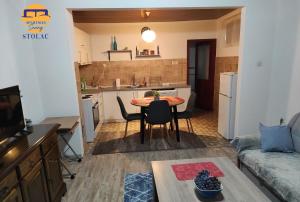 a living room with a table and a kitchen at Apartman Sunny in Stolac
