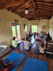 a group of people sitting in a room doing yoga at Ecofazenda Lodge in Bofete