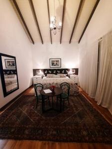 a bedroom with a bed and a table and chairs at Suites Campestres CDG in Rio Negrinho