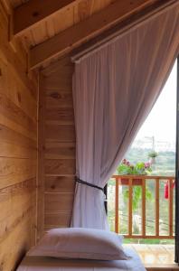 a bed with a canopy in a room with a window at أكواخ الصنوبر in Sawdāʼ +27 photos