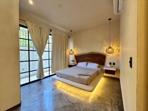 a bedroom with a bed and a large window at Casa Kobaab Tulum in Tulum